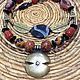 Ethnic necklace made of natural stones in African style in natural colors , black-and-orange - and- brown palette. African ritual artifact .