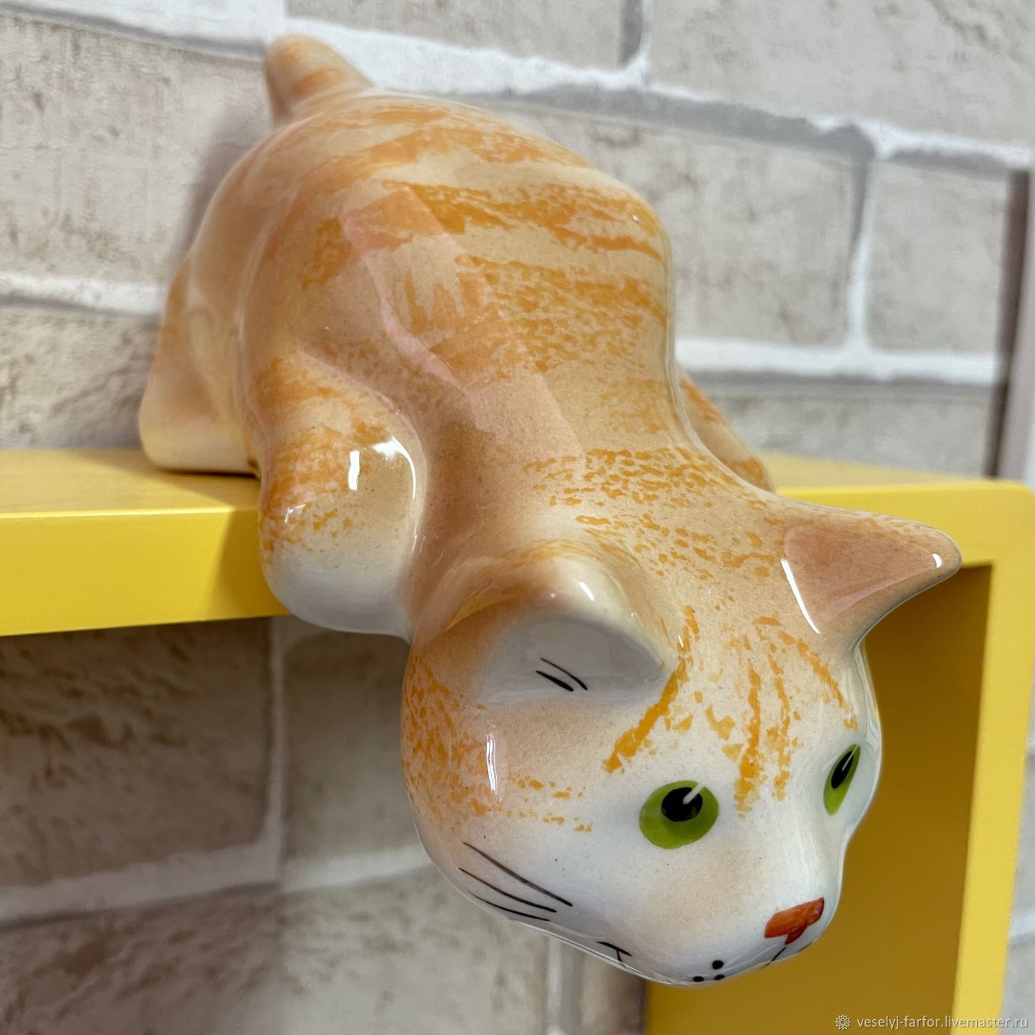 Статуэтка кошка на полку со свисающей лапой