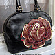 Black bag with bright lush rose can not to draw attention to its owner.