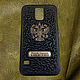 Pad (bumper) on the phone made of genuine leather (pressed leather) with a metal coat of arms of Russia and a personal inscription
