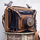 Leather bag, with multiple pockets for all possible gadgets made in the form of an old retro camera. Even the birds have! But they can detach, they are mounted on the buttons.
