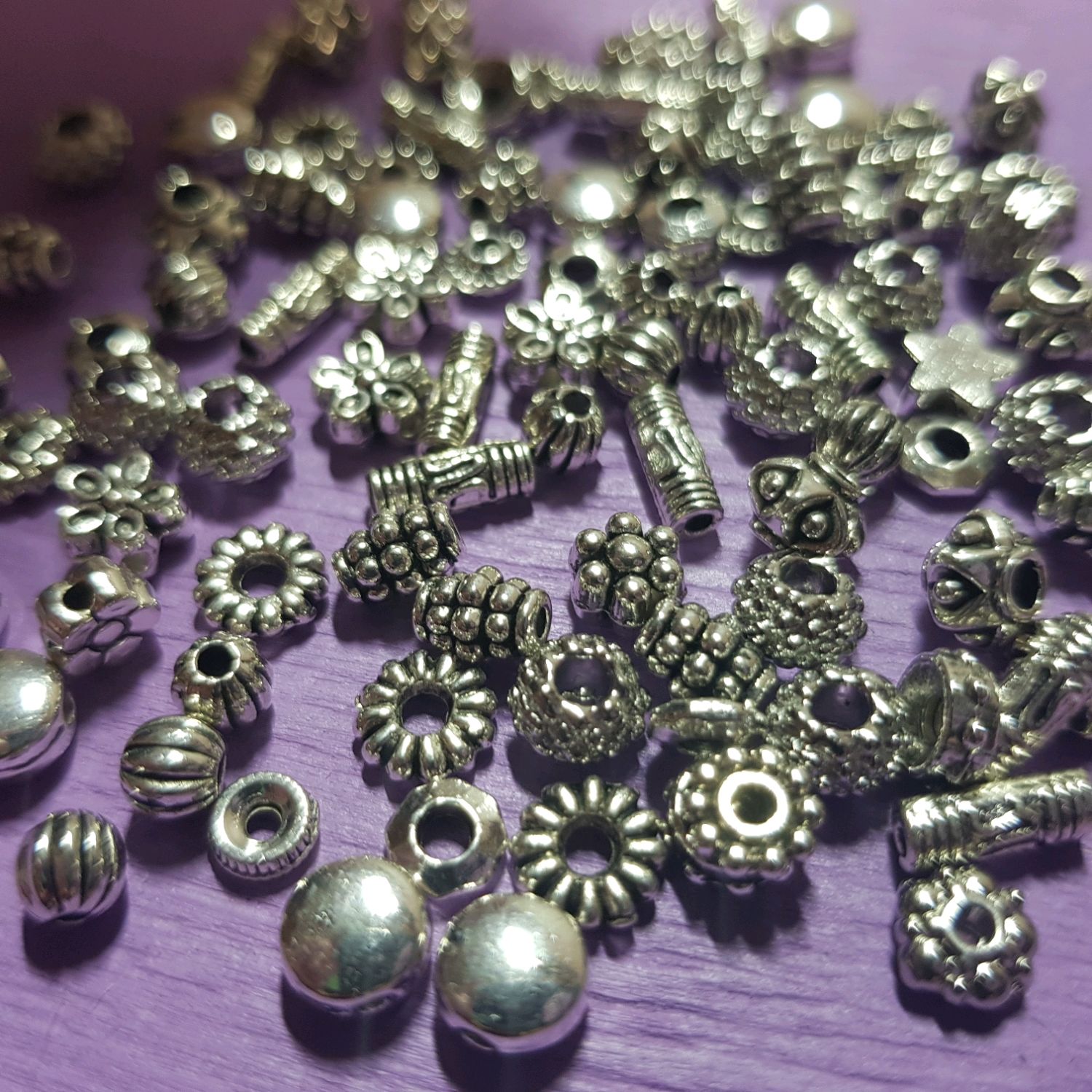 материалы бусин. бусы разноцветные. серебристый мягкий металл. бисер бусины стеклярус. бусины в руках.